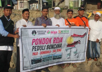 Tim Pondok Roja Peduli Bencana membentangkan spanduk bantuan untuk korban bencana Palu, Donggala, Sulawesi Tengah