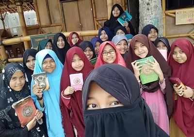 Santriwati Pondok Roja berswafoto bersama sambil memegang mushaf Al-Qur’an