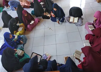 Santriwati duduk melingkar membaca Al-Qur’an dalam halaqah tahfidz