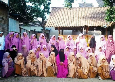 Santriwati Pondok Roja berfoto bersama dengan beragam seragam di halaman pondok