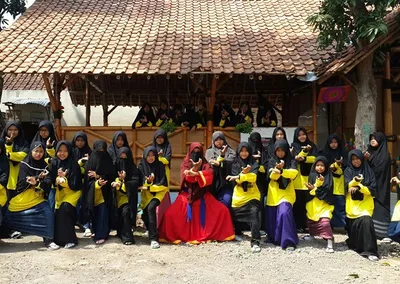 Santriwati berseragam hitam kuning berfoto bersama di depan saung pondok
