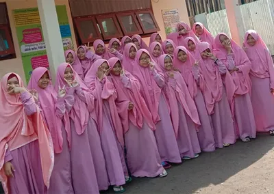 Santriwati berseragam merah muda berfoto bersama di halaman pondok