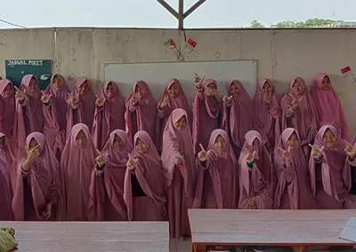 Santriwati berjajar berfoto bersama di depan papan tulis kelas