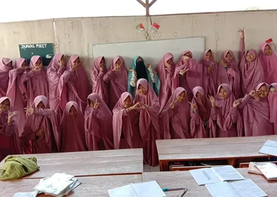 Santriwati berseragam merah muda berfoto bersama di ruang kelas