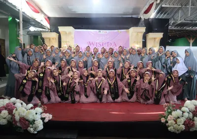 Santriwati kelas 6 dan ustadzah pengabdian berfoto bersama di panggung Haflah Takharruj Pondok Roja